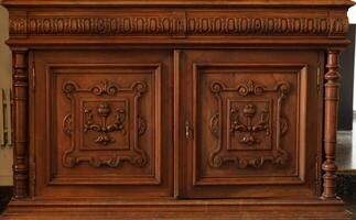 Old vintage wardrobe furniture with ornamental doors and retro colors of wooden surfaces photo