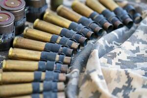 Ukrainian army fabric and machine gun belt shells lies on ukrainian pixeled military camouflage photo