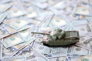 juguete tanque en nosotros cien dólar cuentas Billetes el concepto de guerra costos, militar gasto y económico crisis foto