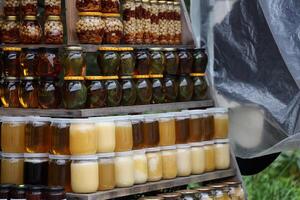 Jars of different honey varieties stocked on a shelf. Lavender, linden and mixed honey photo