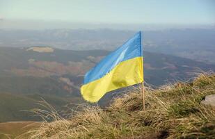 Ukrainian flag on top of Hoverla mountain in Ukraine photo