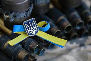 Ukrainian symbol on machine gun belt lies on ukrainian pixeled military camouflage photo