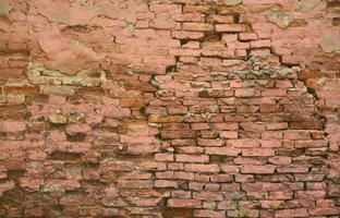 Very old damaged red brick wall with boneless bricks and cement mortar photo