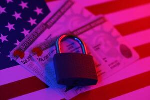Permanent resident green card for US DV-lottery with small padlock on US flag photo