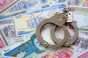 Police handcuffs with iranian money bills rials. The concept of crime and offenses or fraud photo