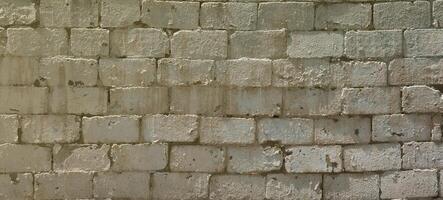 textura de pared de ladrillo de piedras de relieve bajo la luz del sol brillante foto