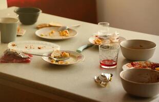 Empty dirty plates with spoons and forks on the table after meal. Banquet ending concept. Unwashed dishes photo