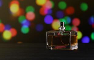 Women fragrance perfume bottle on dark festive background close up. Unnamed blank sprayer bottle of perfume photo