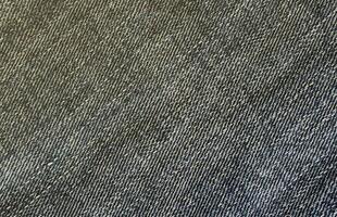 Detailed abstract texture of dark blue denim cloth. Background image of old used denim trousers fabric photo