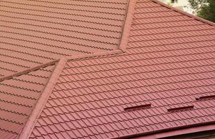 Decorative metal roof tiles in shape of old shingles. Type of roof of the house from a metal profile photo