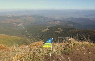 Ukrainian flag on top of Hoverla mountain in Ukraine photo