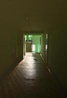 The gloomy corridor of a neglected public building. Public space in a poor residential high-rise building photo