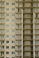 patrón texturizado de una pared de construcción de casas residenciales de piedra blanca rusa con muchas ventanas y balcón en construcción foto