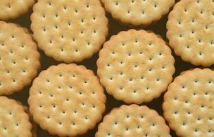 Detailed picture of round sandwich cookies with coconut filling. Background image of a close-up of several treats for tea photo