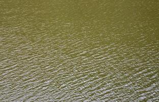 The texture of dark river water under the influence of wind, imprinted in perspective. Horizontal image photo