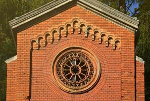 Texture front part of an ancient brick crypt with a round patterned carved window in the cemetery photo