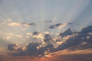 hermosa amanecer con calentar naranja luz de sol y vigas mediante azul cielo foto