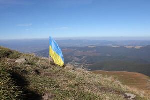 Ukrainian flag on top of Hoverla mountain in Ukraine photo