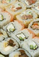 Close-up of a lot of sushi rolls with different fillings. Macro shot of cooked classic Japanese food. Background image photo