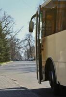 Photo of the hull of a large and long yellow bus. Close-up front view of a passenger vehicle for transportation and tourism