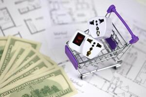 United states standard US outlet in small shopping cart on blueprints of residential house plan. Concept of shopping and electricity devices photo