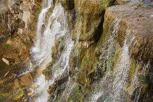 Beautiful waterfall between large rocks in autumn forest. Sofievskiy park in Uman, Ukraine photo