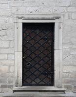 Very old solid door in brick stone wall of castle or fortress of 18th century photo