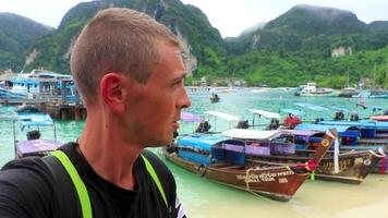 Tourist on Koh Phi Phi island Thailand with longtail boats. video