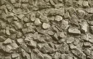 la textura de un fuerte muro de piedra de muchas piedras hormigonadas de diversas formas foto