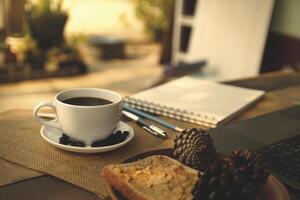 café taza caliente en de madera antiguo mesa en el Mañana foto