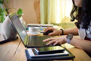 mujer utilizando ordenador portátil trabajando a hogar foto