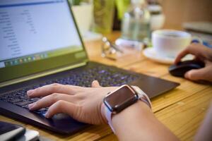 Women using laptop working and drink coffee cup hot at home photo