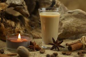 Glass of irish cream liqueur with spice. Cloth background with copy space photo