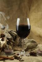 Glass of red wine with spice. Cloth background with copy space photo