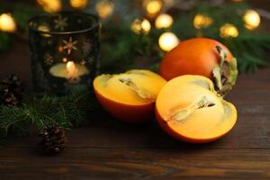 Bright orange persimmons sliced on the wooden background photo