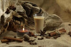 Glass of irish cream liqueur with spice. Cloth background with copy space photo