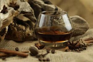 Glass of cognac with spice. Cloth background with copy space photo