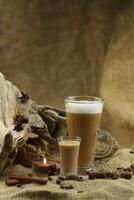 Glass coffee with glass of irish cream liqueur and spices. Cloth background with copy space photo