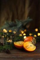 Bright orange persimmons sliced on the wooden background photo