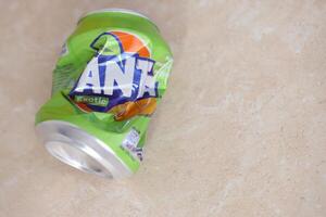 KYIV, UKRAINE - 4 MAY, 2023 Fanta soft drink brand crumpled tin can with exotic flavour photo