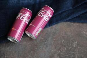 KYIV, UKRAINE - 4 MAY, 2023 Coca cola soft drinks brand tin cans with cherry flavour photo