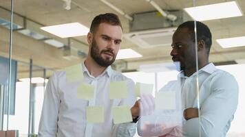 twee verschillend ontwerpers planning Aan een glas bord. planning is de eerste stap video