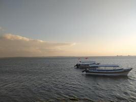 dos barcos son flotante en el mar, temprano Mañana foto