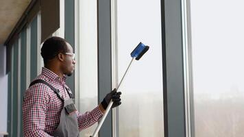 Professional window washer black man washing window indoors video