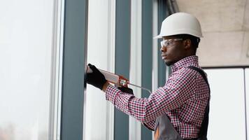 African windows installation worker use of silicone foam when installing pvc windows video