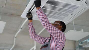 Black worker checks air conditioner in office video