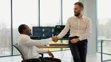 Team of stockbrokers are having a conversation in office with display screens. Analyzing data, graphs and reports for investment purposes. Creative teamwork traders video