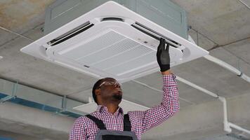 Worker sets up air conditioner in office video