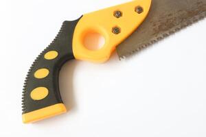 Hand saw with yellow plastic handle photo