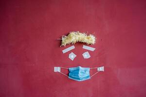 visual art of the image of a person's face on the wall, creative approach to the image of a patient in a mask, protective medical mask in a minimalistic concept, drawing on a maroon wall photo